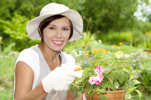 Gardener at work in a front garden with tools