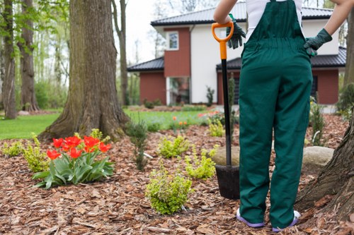 Garden maintenance crew performing seasonal pruning and cleanup