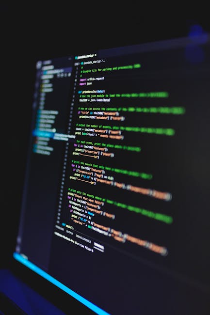 The image shows a close-up of a computer screen displaying lines of colorful programming code on a dark background. The code is written in a text editor with syntax highlighting, featuring various col